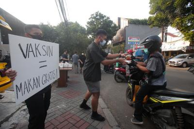 Barista membagikan makanan siap saji di depan Kopi Muja, Kebayoran Baru, Jakarta Selatan, Jumat (16/7/2021).