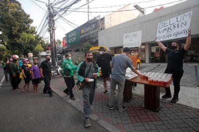 Barista membagikan makanan siap saji di depan Kopi Muja, Kebayoran Baru, Jakarta Selatan, Jumat (16/7/2021).