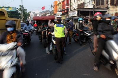 Petugas gabungan mengatur arus lalu lintas saat penyekatan masa PPKM Darurat di kawasan Sandartex Ciputat Tangerang Selatan, Jakarta, Jumat (16/7/2021).