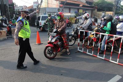 Petugas gabungan mengatur arus lalu lintas saat penyekatan masa PPKM Darurat di kawasan Sandartex Ciputat Tangerang Selatan, Jakarta, Jumat (16/7/2021).