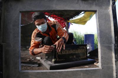 Perajin menyelesaikan pembuatan batu nisan disalah satu rumah produksi Keputih Surabaya, Jawa Timur, Jumat (16/7/2021).