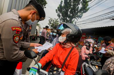 Petugas saat memeriksa kelengkapan warga yang ingin melintas di pos penyekatan PPKM Darurat Lenteng Agung, Jakarta Selatan, Jumat (16/7/2021).