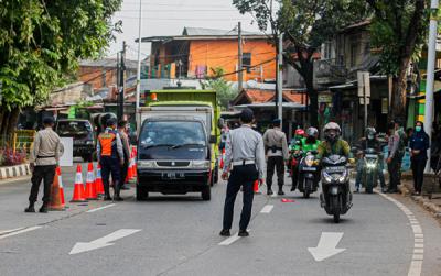 Petugas saat memeriksa kelengkapan warga yang ingin melintas di pos penyekatan PPKM Darurat Lenteng Agung, Jakarta Selatan, Jumat (16/7/2021).