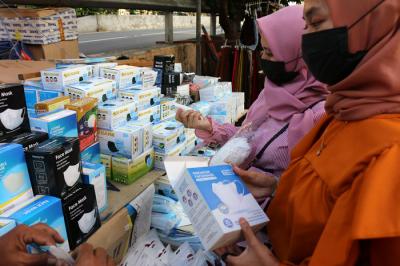 Pedagang masker melayani pembeli di kawasan Pasar Pagi Lama, Jakarta, Sabtu (17/7/2021).
