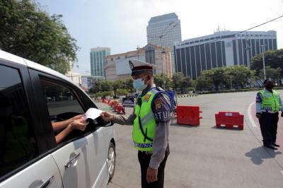Petugas kepolisian memeriksa kendaraan di pos penyekatan PPKM Darurat di kawasan Jalan Jenderal Sudirman, Jakarta, Sabtu (17/7/2021).