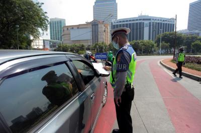Petugas kepolisian memeriksa kendaraan di pos penyekatan PPKM Darurat di kawasan Jalan Jenderal Sudirman, Jakarta, Sabtu (17/7/2021).