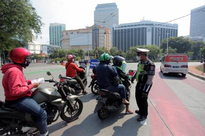 Petugas kepolisian memeriksa kendaraan di pos penyekatan PPKM Darurat di kawasan Jalan Jenderal Sudirman, Jakarta, Sabtu (17/7/2021).