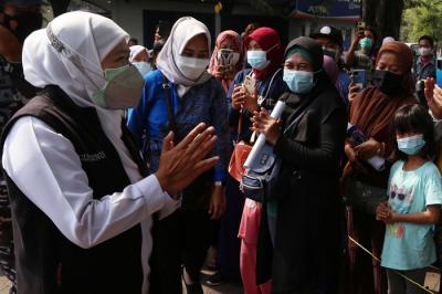 Ajudan menyemprotkan cairan disinfektan kepada Gubernur Jawa Timur Khofifah Indar Parawansa sebelum masuk ke mobil di Jawa Timur, Minggu (18/7/2021).