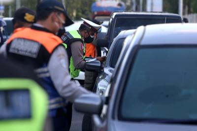 Petugas melakukan pengecekan dokumen pengendara yang melintas di pos penyekatan Jembatan Suramadu, sisi Surabaya, Jawa Timur, Senin (19/7/2021).