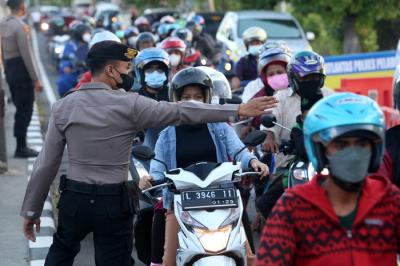 Petugas melakukan pengecekan dokumen pengendara yang melintas di pos penyekatan Jembatan Suramadu, sisi Surabaya, Jawa Timur, Senin (19/7/2021).