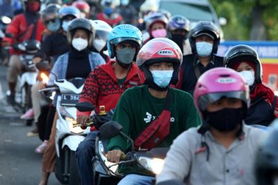 Petugas melakukan pengecekan dokumen pengendara yang melintas di pos penyekatan Jembatan Suramadu, sisi Surabaya, Jawa Timur, Senin (19/7/2021).