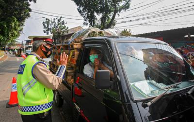 Petugas memeriksa warga yang ingin melintas untuk mengantar pesanan hewan kurban di pos penyekatan PPKM Darurat Lenteng Agung, Senin (19/7/2021).