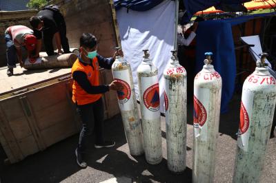 Petugas mengisi ulang tabung oksigen di halaman Dinas Perhubungan Jatim Jalan Ahmad Yani Surabaya, Jawa Timur, Senin (19/7/2021).
