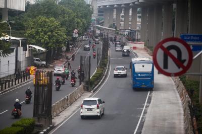 Pengendara melintas di dekat tiang-tiang bekas proyek monorel di Jalan Rasuna Said, Kuningan, Jakarta, Senin (19/7/2021).