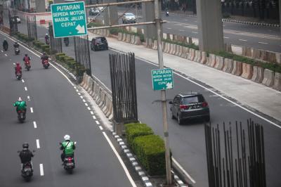 Pengendara melintas di dekat tiang-tiang bekas proyek monorel di Jalan Rasuna Said, Kuningan, Jakarta, Senin (19/7/2021).