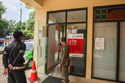 Petugas Satpol PP mengatur antrean warga yang ingin mencairkan Bantuan Langsung Tunai di Kecamatan Makasar, Jakarta Timur, Selasa (20/7/2021).