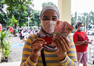 Petugas Satpol PP mengatur antrean warga yang ingin mencairkan Bantuan Langsung Tunai di Kecamatan Makasar, Jakarta Timur, Selasa (20/7/2021).