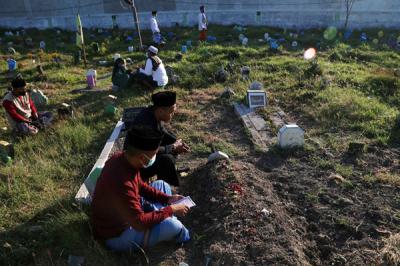 Peziarah mendoakan orang tua dan sanak keluarganya yang telah meninggal ketika berziarah di Makam Islam Sidoarjo, Jawa Timur, Selasa (20/7/2021).