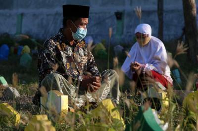 Peziarah mendoakan orang tua dan sanak keluarganya yang telah meninggal ketika berziarah di Makam Islam Sidoarjo, Jawa Timur, Selasa (20/7/2021).