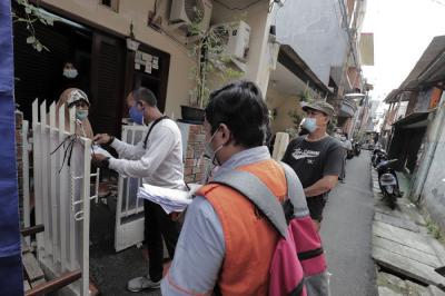 Juru Bayar Kantor Pos Indonesia memotret warga penerima Bantuan Sosial Tunai (BST) di wilayah Kelurahan Petojo Selatan, Jakarta, Rabu (21/7/2021).