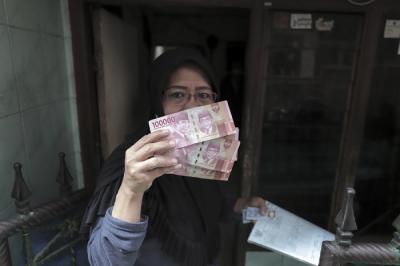 Juru Bayar Kantor Pos Indonesia memotret warga penerima Bantuan Sosial Tunai (BST) di wilayah Kelurahan Petojo Selatan, Jakarta, Rabu (21/7/2021).