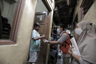 Juru Bayar Kantor Pos Indonesia memotret warga penerima Bantuan Sosial Tunai (BST) di wilayah Kelurahan Petojo Selatan, Jakarta, Rabu (21/7/2021).