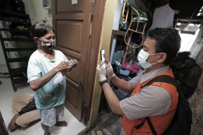 Juru Bayar Kantor Pos Indonesia memotret warga penerima Bantuan Sosial Tunai (BST) di wilayah Kelurahan Petojo Selatan, Jakarta, Rabu (21/7/2021).