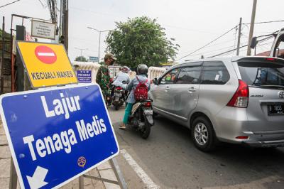 Petugas saat berjaga di sejumlah titik pos penyekatan di kawasan Jakarta, Rabu (21/7/2021).