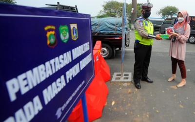 Pegawai PT Bank Tabungan Negara (Persero) Tbk membagikan makanan dan hand sanitizer kepada petugas di kawasan Samsat Daan Mogot, Jakarta, Kamis (22/7/2021).