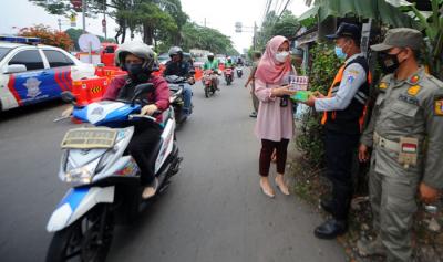 Pegawai PT Bank Tabungan Negara (Persero) Tbk membagikan makanan dan hand sanitizer kepada petugas di kawasan Samsat Daan Mogot, Jakarta, Kamis (22/7/2021).
