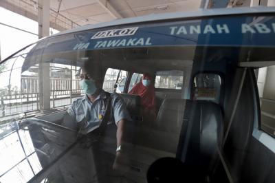 Supir angkutan Jak Lingko mengenakan masker saat menunggu penumpang di Tanah Abang, Jakarta, Kamis (22/7/2021).