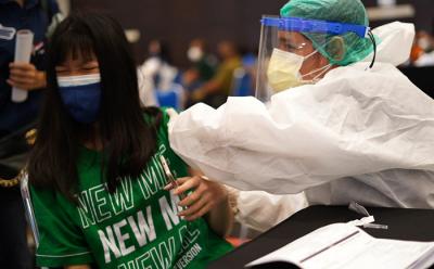 Warga mendapat suntikan vaksin Covid-19 ketika mengikuti vaksinasi massal yang digelar PT Bank Pembangunan Daerah Jawa Timur Tbk.