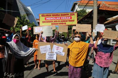 Puluhan warga berorasi dan membentangkan poster ketika aksi didepan SDN Baratajaya Surabaya, Jawa Timur, Jumat (23/7/2021).