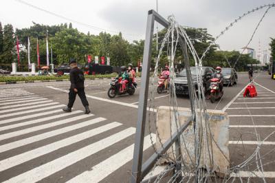 Pengendara melintasi kawat berduri yang terpasang di kawasan Harmoni, Jakarta Pusat, Sabtu (24/7/2021).