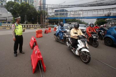 Pengendara melintasi kawat berduri yang terpasang di kawasan Harmoni, Jakarta Pusat, Sabtu (24/7/2021).