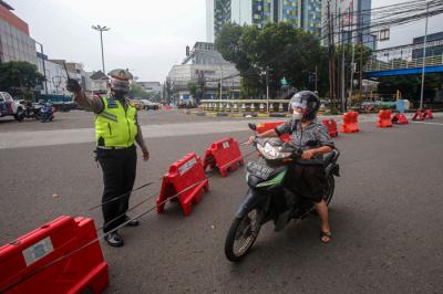 Pengendara melintasi kawat berduri yang terpasang di kawasan Harmoni, Jakarta Pusat, Sabtu (24/7/2021).