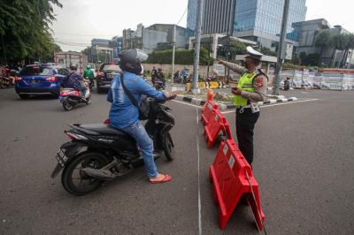 Pengendara melintasi kawat berduri yang terpasang di kawasan Harmoni, Jakarta Pusat, Sabtu (24/7/2021).