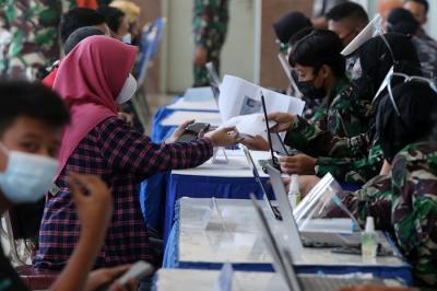 Peserta vaksin menutup muka ketika mendapat suntikan vaksin Covid-19 dalam serbuan vaksin masyarakat maritim di Gedung GSN, Jawa Timur, Senin (26/7/2021).