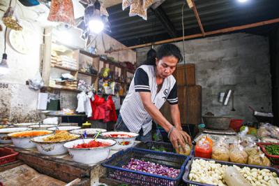 Pedagang merapikan dagangannya di Pasar Pondok Gede, Kota Bekasi, Jawa Barat, Senin (26/7/2021).