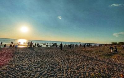 Suasana pengunjung menikmati matahari terbenam di Pantai Indah Bosowa, Makassar, Minggu (25/7/2021).