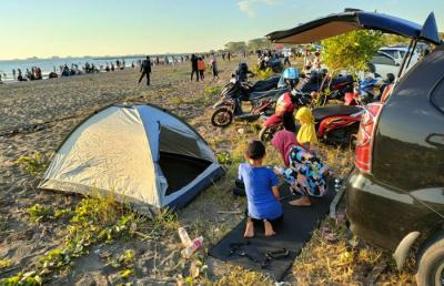Suasana pengunjung menikmati matahari terbenam di Pantai Indah Bosowa, Makassar, Minggu (25/7/2021).