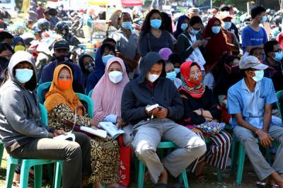 Suasana antrean pengambilan Bantuan Sosial Tunai (BST) di Lapangan Pacar Keling, Surabaya, Jawa Timur, Selasa (27/7/2021).