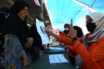 Suasana antrean pengambilan Bantuan Sosial Tunai (BST) di Lapangan Pacar Keling, Surabaya, Jawa Timur, Selasa (27/7/2021).