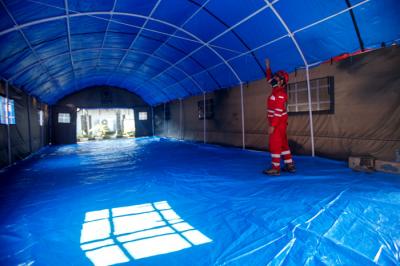 Petugas Palang Merah Indonesia (PMI) memeriksa kesiapan selter atau tenda darurat untuk pasien isolasi mandiri Covid-19 di Jakarta, Selasa (27/7/2021).