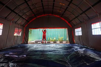 Petugas Palang Merah Indonesia (PMI) memeriksa kesiapan selter atau tenda darurat untuk pasien isolasi mandiri Covid-19 di Jakarta, Selasa (27/7/2021).