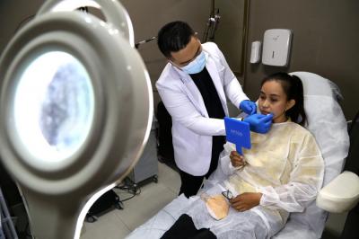 Dokter Michael Lawanto melakukan perawatan kulit wajah pasien di Beauty Skin dr MF Surabaya, Jawa Timur, Rabu (28/7/2021).