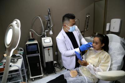 Dokter Michael Lawanto melakukan perawatan kulit wajah pasien di Beauty Skin dr MF Surabaya, Jawa Timur, Rabu (28/7/2021).
