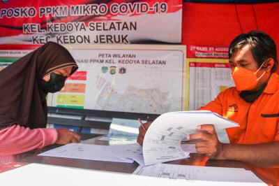 Warga saat menerima bantuan sosial (bansos) tunai di kawasan Kedoya Selatan, Jakarta Barat, Rabu (28/7/2021).