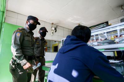 Petugas Satpol PP bersama TNI dan Polisi memberikan sosialisasi kepada pemilik rumah makan di kawasan Margonda, Depok, Jawa Barat, Rabu (28/7/2021).