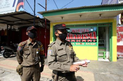 Petugas Satpol PP bersama TNI dan Polisi memberikan sosialisasi kepada pemilik rumah makan di kawasan Margonda, Depok, Jawa Barat, Rabu (28/7/2021).